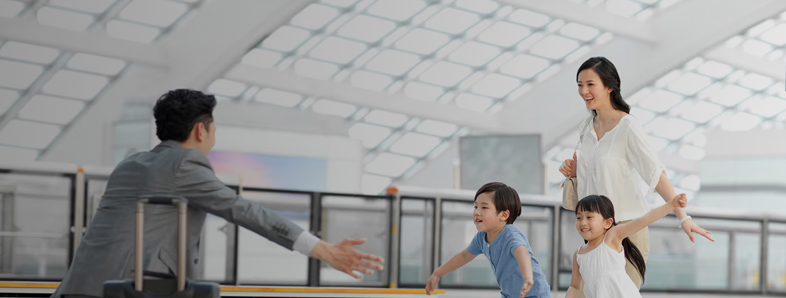 Kinderen rennen blij naar hun vader met koffer bij aankomst op de luchthaven