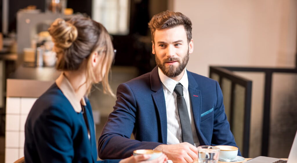 Man met baard in pak overlegt met vrouw
