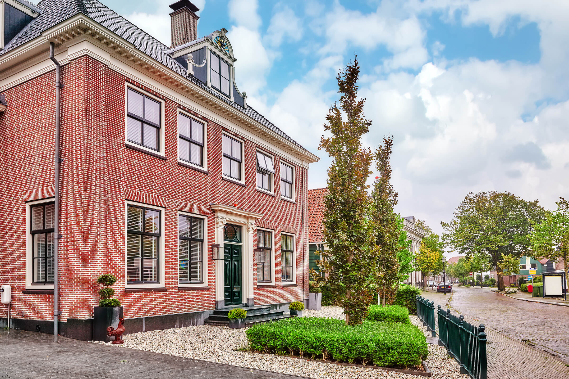 Klassiek Nederlands herenhuis van rode baksteen met verzorgde voortuin aan een rustige straat