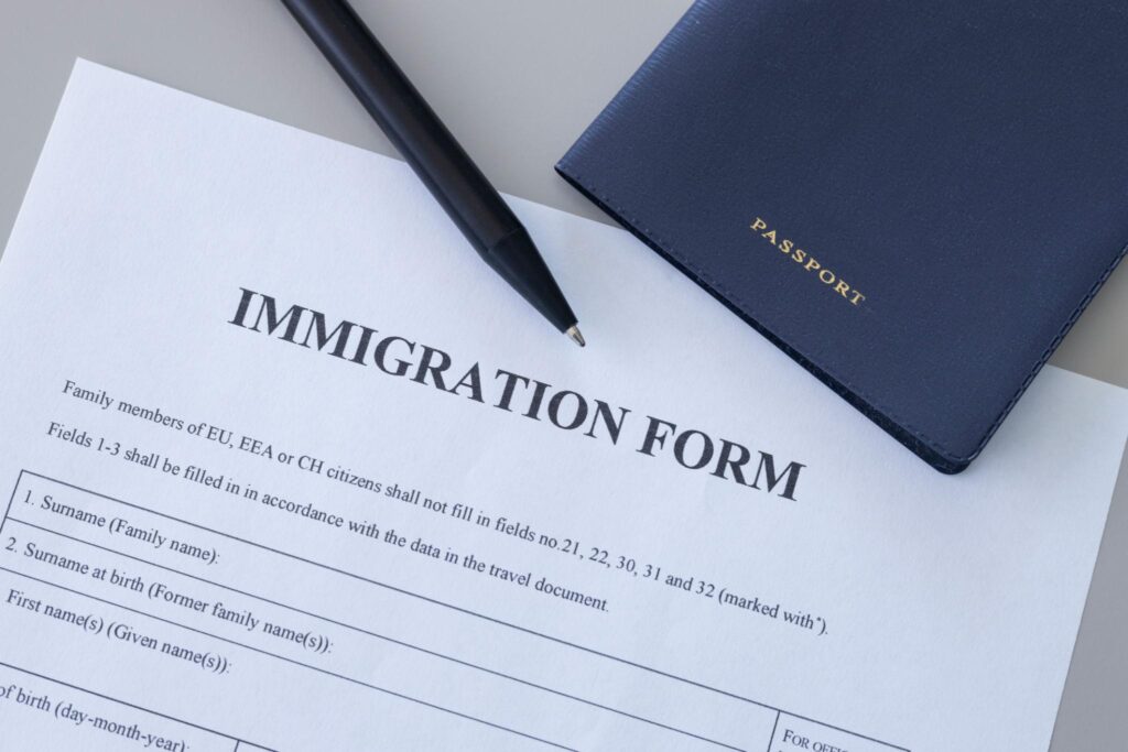 Immigratieformulier met pen en paspoort op een bureau